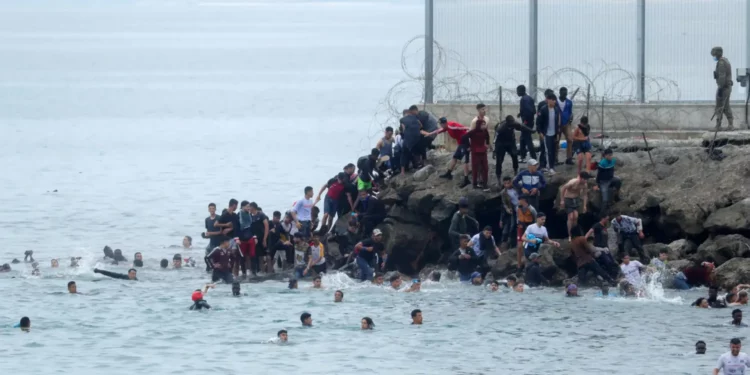 Les autorités de l'enclave espagnole de Ceuta ont demandé au gouvernement de Madrid de déclarer l'urgence nationale et ont sollicité l'intervention de l'armée, alors que des milliers de migrants ont rejoint ce territoire situé sur la côte nord du Maroc. Selon les autorités locales, plus de 1 500 migrants, adultes et mineurs, sont arrivés par la mer en seulement quelques jours. La majorité sont des Marocains, rejoints par quelques Algériens installés au Maroc dans l'espoir de rejoindre l'Europe. Cet afflux inédit met les infrastructures locales sous forte pression. Les centres d'accueil sont saturés et des centaines de migrants dorment désormais à l'extérieur, faute de places disponibles. Les secours espagnols, avec le soutien de la Croix-Rouge, multiplient les opérations de sauvetage en mer pour récupérer les nageurs avant leur arrivée sur les côtes. Cette vague d'arrivées intervient alors qu'une récente décision du Tribunal suprême espagnol interdit désormais les refoulements immédiats des migrants arrivés par voie maritime, leur garantissant un examen individuel de leur situation. Le ministre espagnol de l'Intérieur a reconnu une situation « exceptionnelle », tout en affirmant que les moyens déployés restaient suffisants pour y faire face. La route vers Ceuta reste particulièrement dangereuse. Selon les autorités locales, une soixantaine de corps ont été retrouvés en mer dans cette zone au cours de l'année écoulée.