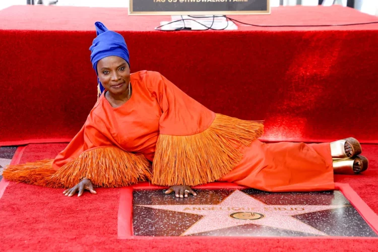 Angélique Kidjo, cinq fois lauréate d'un Grammy, est devenue, mardi, la première Africaine noire à se voir décerner une étoile sur le Walk of Fame d'Hollywood. Lors d'une cérémonie fastueuse organisée sous les palmiers et sous un ciel californien digne d'une carte postale, Kidjo a été mise à l'honneur par des stars de cinéma et des grands noms de l'industrie musicale alors qu'elle dévoilait son étoile sur cette artère très fréquentée. « Nous, les Africains, nous ne savons pas tout ce que nous avons apporté au monde », a déclaré cette femme de 66 ans. « Sans nous, la musique serait impossible sur cette planète. » Après avoir remercié son équipe et sa famille, Kidjo s'est mise à chanter tandis que les personnes présentes l'écoutaient avec une attention captivée. Née au Bénin, Kidjo mène une carrière internationale depuis plus de 40 ans et compte 18 albums à son actif. En plus d'avoir été désignée comme l'une des 100 personnalités les plus influentes par le magazine Time, elle a également été désignée comme l'une des 50 figures les plus emblématiques d'Afrique par la BBC et comme l'une des 100 personnalités les plus inspirantes au monde par The Guardian. Harvey Mason Jr., de la Recording Academy, a salué Kidjo en la qualifiant d'« artiste exceptionnelle ». « Votre exemple a enrichi notre communauté musicale mondiale et votre travail ne cesse de nous rappeler que la musique est bien plus qu'un simple divertissement : c'est un lien », a-t-il déclaré. « Cette étoile est un symbole éternel ; elle ne disparaîtra jamais et elle symbolise vos réalisations. Mais votre héritage, lui, perdure à travers les personnes que vous avez touchées, que vous avez inspirées, les barrières que vous avez brisées, les liens que vous avez tissés aux quatre coins du monde. » L'acteur Willem Dafoe a salué l'immense énergie dont fait preuve Kidjo sur scène. « La première fois que j'ai vu Angélique se produire sur scène, j'ai trouvé que sa musique, sa danse et son engagement étaient incroyables », a déclaré la star de « Platoon ». « C'est, sans aucun doute, la femme la plus travailleuse du monde du spectacle. » Mais, a-t-il ajouté, ce qui était encore plus impressionnant, c'était son engagement en faveur de l'action humanitaire de sa fondation Batonga, qui œuvre pour l'autonomisation des filles et des jeunes femmes en Afrique. « Il ne s'agit pas d'un engagement symbolique de la part d'une célébrité ; c'est le prolongement de ce qu'elle fait à travers sa musique. Elle nous touche, nous inspire et nous rappelle que nous sommes tous liés, et que l'amour et la compréhension sont la voie à suivre. »
